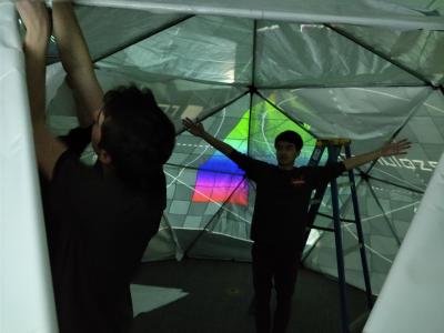 Students attach plastic panels from the inside while a calibration frame is being projected.