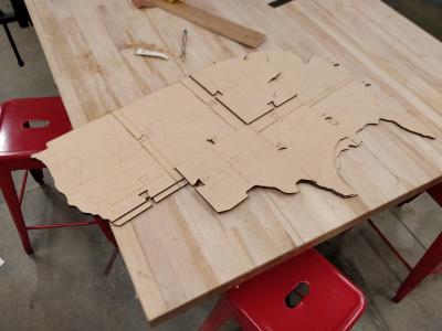 Interlocked segments of plywood forming a partial outline of the United States.